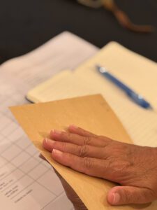 Une enveloppe cachetée avec une main posée dessus pour un exercice de remote viewing et développement du 6ème sens